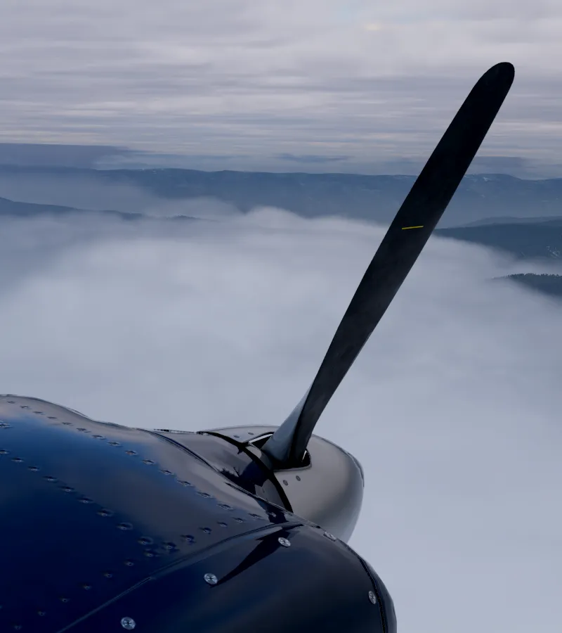 Stopped propeller above a cloud layer with mountains beyond